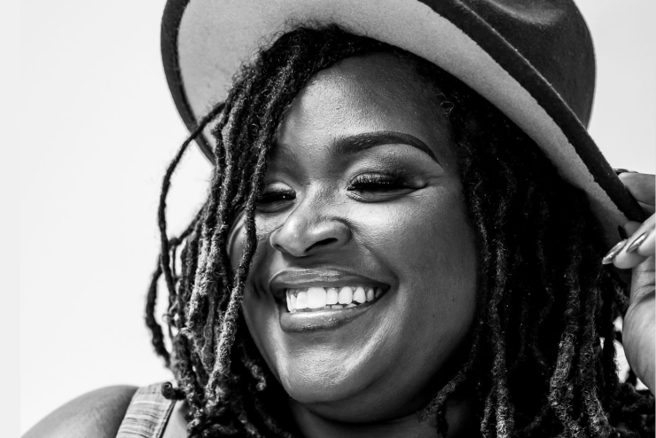 Marquita Stewart holds onto her hat and smiles. 