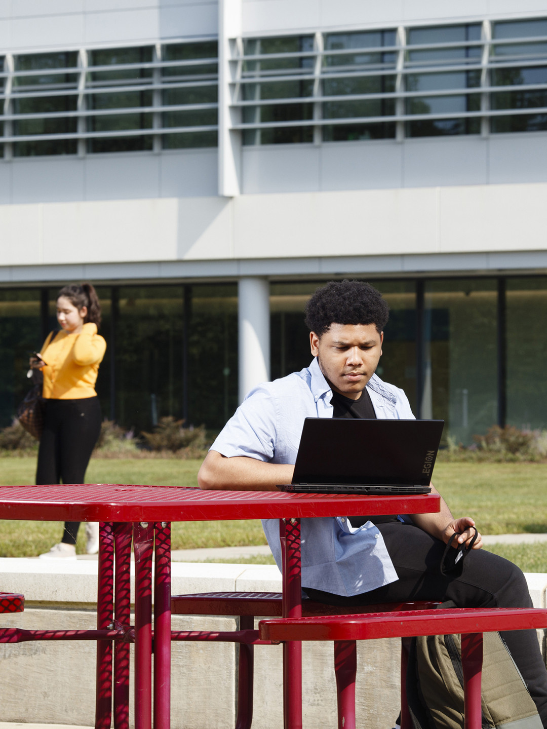 Student on laptop in Midlothian courtyard