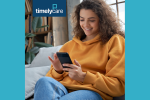 Woman who is smiling as she looks at her smartphone