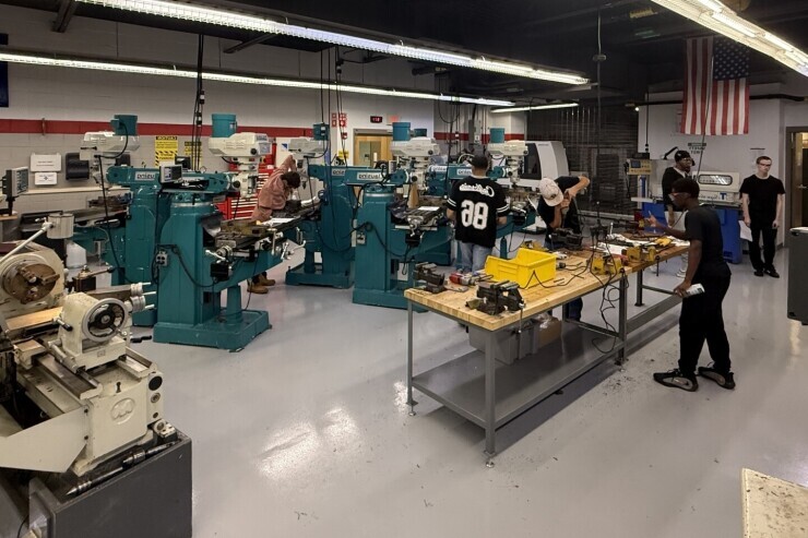 Students working on manual tools in the precision machining lab at the Chester Campus, surrounded by large machines and equipment. 