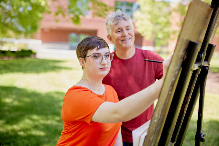 A Brightpoint Visual Arts student painting with faculty. 