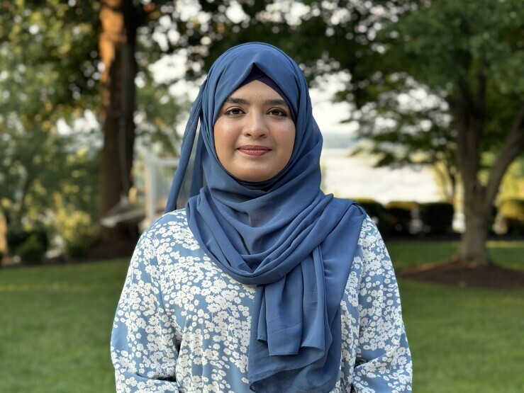 Aneeza Khan poses outside, smiling serenely. 