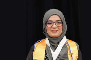 Aneeza wears a golden Phi Theta Kappa (PTK) stole and a student award medal while posing at the 2026 Student Awards Ceremony. 