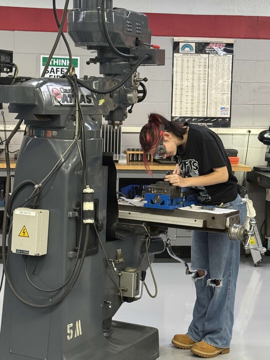 A student leans in close to look at her work in the precision machining lab at Brightpoint's Chester Campus. 