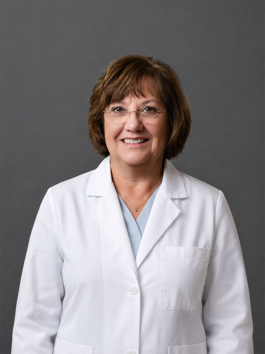 Headshot of Dr. Nancy Leahy wearing a white lab coat on gray background