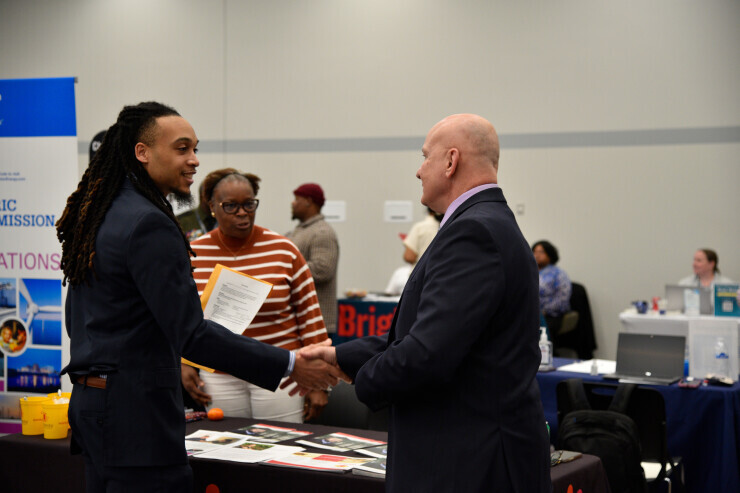 A student shakes the hand of an employer representative at a Chester Campus career fair. 