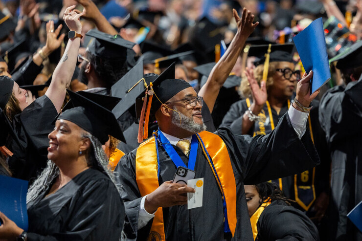 Group of grads waving and cheering.