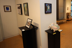 Wide view of the Art Gallery of Brightpoint with various artwork hanging on the walls and artwork sitting on pedestals.