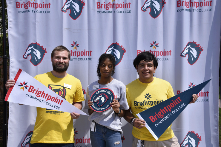links to A Brightpoint staff member and student ambassadors pose in front of a trailblazer banner. 