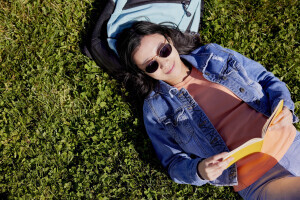 A student reading on the grass. 
