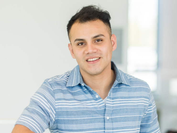 Smiling student leaning against a rail