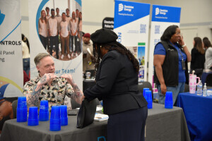 An individual in professional clothing speaks to an employer at a career fair in Chester. 