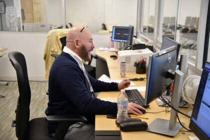 A Brightpoint Testing Coordinator at his desk.