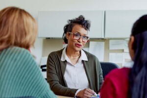 Staff in the Help Hub working with two students