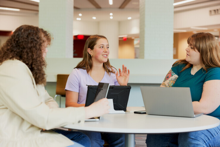links to Three students smile and engage in conversation while studying at a Brightpoint campus.