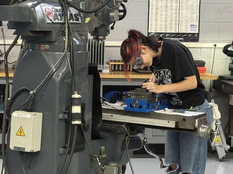 A student leans in close to look at her work in the precision machining lab at Brightpoint's Chester Campus. 