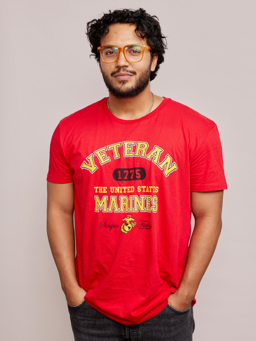 A Brightpoint student wears a red Marines shirt and smiles, his hands in his pockets. 