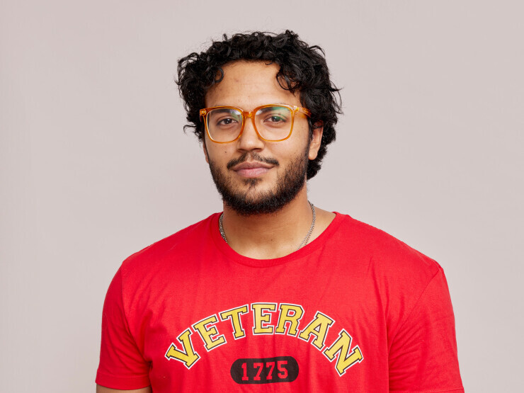 A Brightpoint student wears a red Marines shirt and smiles, his hands in his pockets.