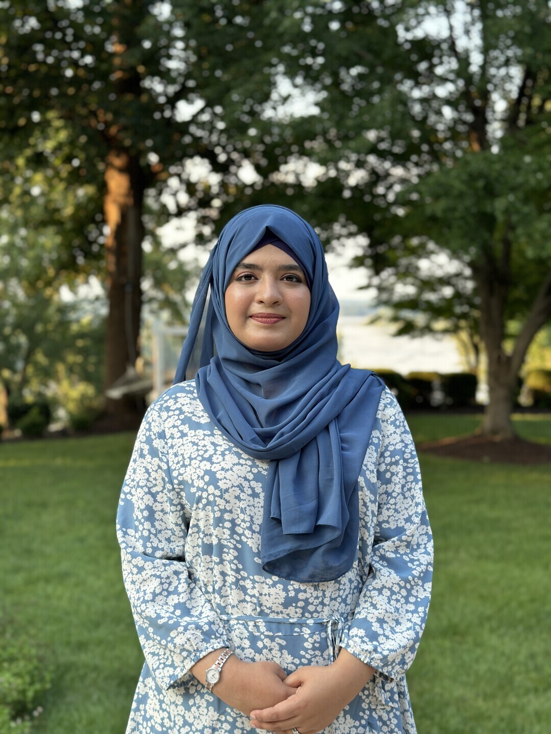 Aneeza Khan poses outside, smiling serenely. 