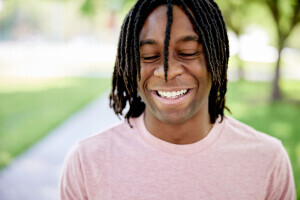 A student with locks smiles. 