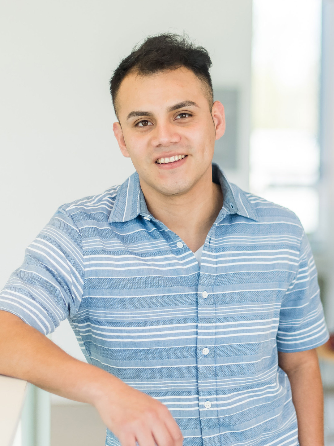 Smiling student leaning against a rail