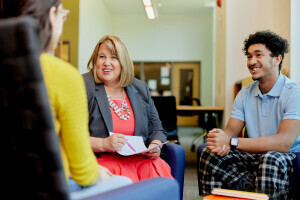 A Career Services advisor smiles while helping a group of Brightpoint students. 