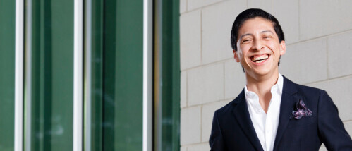 A Brightpoint student in a suit smiles confidently.