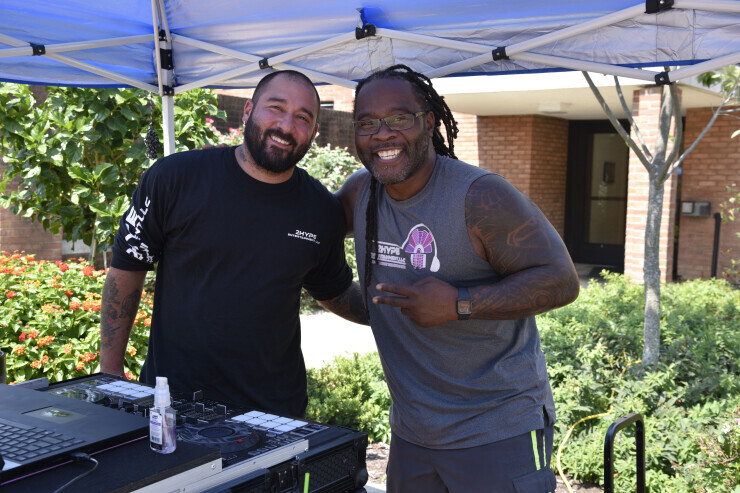 links to A Brightpoint student poses with the DJ at a Welcome Back event on Brightpoint's Chester Campus.
