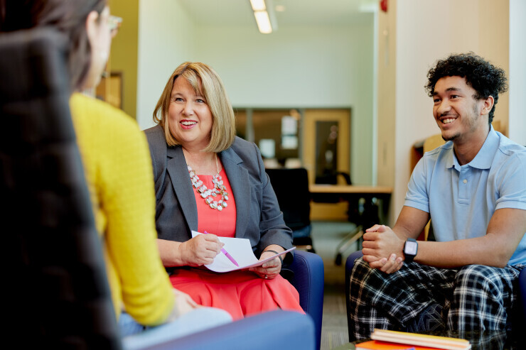 A Career Services advisor smiles while helping a group of Brightpoint students. 
