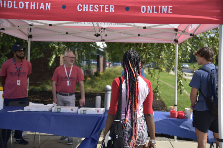 A Brightpoint student visits a welcome table at the Midlothian Campus. 